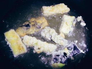 7、鱼香茄子,炒锅内加入色拉油100g左右，油温烧至4成热，将裹好蛋液和淀粉的茄子逐个下入油锅炸制。