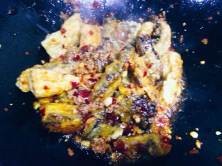 14、鱼香茄子,将调好的味汁沿锅边滑入一半，快速翻炒均匀。