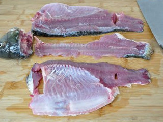 1、最美川式下饭菜：酸菜鱼 ,用锋利的快刀，从鱼尾处开始，沿着鱼骨将两片鱼肉切割下来；鱼骨剁成小段，跟鱼头一起留着煮汤做底汤用。