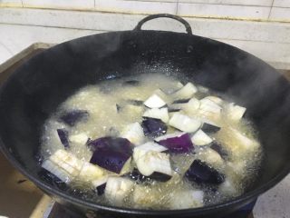 3、#年夜饭#红烧豆瓣酱茄子,锅内加油，烧成七成熟。把切好的茄子入锅。过油。
