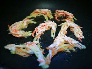 11、圆土豆~炸假虾,锅中倒油 将土豆胡萝卜丝用筷子夹入锅中