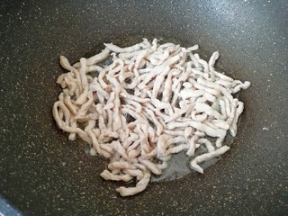 4、鱼香肉丝,炒锅内倒适量的食用油烧热,下入腌制好的肉丝,大火快速划炒至肉丝变色盛出备用。