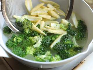 3、炒三脆,锅中加入清水烧开，加入些许盐和油，放入西兰花和玉米笋，焯水两分钟，然后捞出用冷水冲凉，沥去水分。