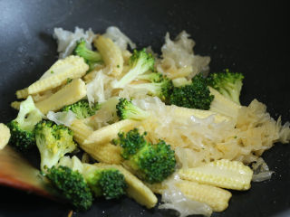 7、炒三脆,随后放入银耳、玉米笋和西兰花翻炒片刻。