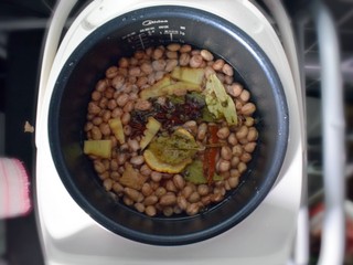 4、水煮花生米（电饭煲版）,将花生洗净放入电饭煲中，加入适量的水（一定要没过花生哦），并将调料和生姜倒入，浸泡半个小时。