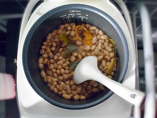 9、水煮花生米（电饭煲版）,20分钟后，打开盖子，再用勺子搅拌几下。