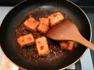 21、鱼香脆皮豆腐,用铲子,快速翻拌均匀,使豆腐裹上酱汁,关火,盛出