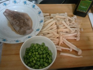 4、健康低卡香煎鲈鱼,准备腌制好的鲈鱼片，一小碗小豌豆。和一把海鲜菇