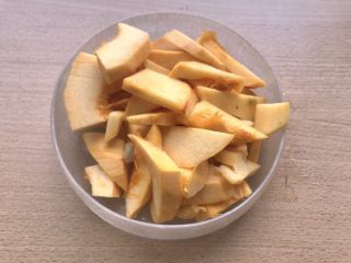 2、辣炒南瓜,将南瓜切半去皮切厚片。如何切南瓜在我《南瓜枸杞粥》里有很详细的介绍。