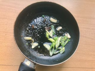 8、辣炒南瓜,热锅凉油，放入一半！注意是一半！的大蒜和大葱。葱蒜有先后的话一是色泽好看（金银蒜和一部分鲜绿的葱绿）二是香味会有层次！这是麻麻这道菜的独门配方！