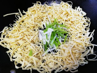 10、凉拌千张,挑去花椒大料，把千张丝放入炸完油的凉锅里，放入葱丝。