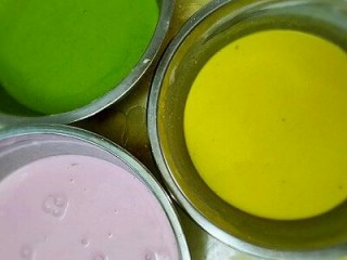 8、彩色凉皮,沉淀一个晚上的粉浆倒去面上的水,慢慢倒干净后,用大勺子把底下沉淀的浆搅拌均匀,分别加入,蔬菜汁,如图