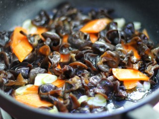 7、腐竹烧木耳,放入木耳和胡萝卜翻炒两分钟左右