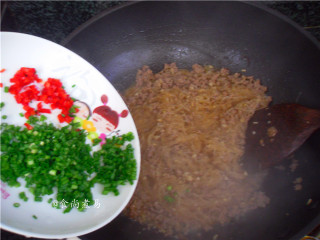 10、蚂蚁上树,接着倒入泡软的粉条，调入酱油，翻炒至粉条吸足汤汁，撒下葱花和辣椒碎