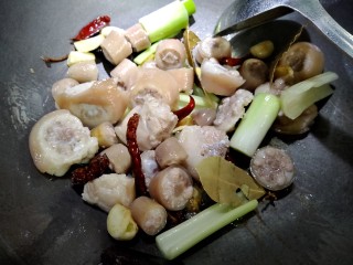 7、节节香,把焯好水的猪尾放入，中火翻炒，然后加入两大勺料酒。