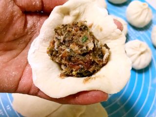 17、芽菜猪肉馅包子,取一块面皮，放入1勺馅料