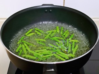 5、芦笋时蔬小炒,炒锅中加入纯净水，大火烧开，下入切好的芦笋，大火焯水1分钟立刻捞出过冷水。