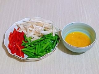 6、芦笋时蔬小炒,鸡蛋磕入碗中，用筷子打散，准备工作完成。