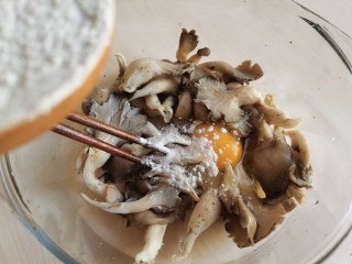 6、炸平菇（多口味超详细）,加入适量面粉。面粉不要一次加太多，先搅拌看看面糊的稠度，不够再加。