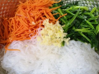 9、凉拌菠菜粉丝,用压蒜器压好蒜泥放入。