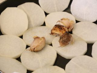 8、干烧萝卜,放入切好的白萝卜,在锅底铺平,小火慢煎。