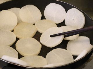 9、干烧萝卜,一面煎变色后,用筷子翻另外一面继续煎。