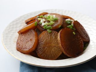 12、干烧萝卜,最后几分钟调大火力收汁,装盘,撒少许葱花装饰即可。