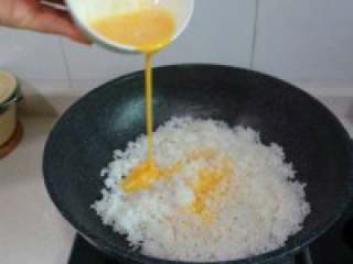 5、 五彩冰芬【圣诞炒饭】,米饭炒得比较干爽时,淋入打散 的鸡蛋液继续翻炒。