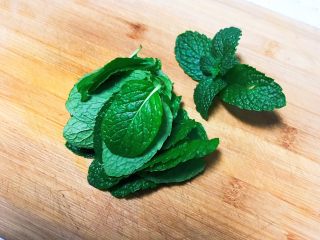 3、薄荷厚蛋烧,把薄荷叶放在砧板上