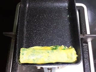 13、薄荷厚蛋烧,把卷好的蛋卷移到蛋烧锅的上边