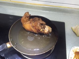 8、焦皮肘子,平底锅放少许色拉油，烧热后放入猪肘，让猪皮贴着锅底进行烙煎，中途注意翻转以让所有猪皮都能煎到，此步要注意，油很容易爆溅起来，小心烫伤，戴上口罩操作好些