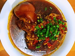 16、焦皮肘子,将调味汁淋在香肘上，撒上葱花，就ok了