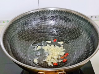 8、爆炒卷心菜,起油锅，加入蒜末与辣椒煸炒。