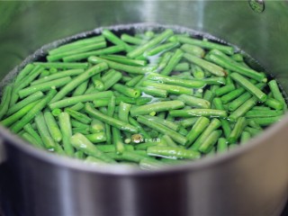 4、响油豇豆,锅内坐水，水烧开后倒入豇豆，加少许食盐，食用油汆烫两三分钟。