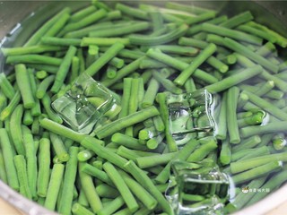 5、响油豇豆,将焯熟的豇豆浸入冰水中过凉，捞出沥去水分，备用。