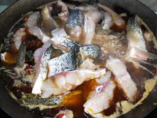 7、酸菜红烧鱼,锅里加入水，按照顺序放入鱼头、鱼块，盖上锅盖一起煮