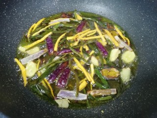 8、菌菇素辣酱,下入准备好的小葱叶、洋葱、生姜、胡萝卜和所有的香辛料，小火炸至所有食材微微焦黄(需要8–10分钟左右)，全部捞出不要。