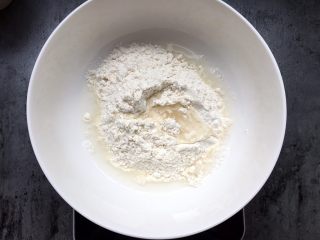 2、四川乐山名小吃—粉蒸肉卡饼,将面粉加入温水搅匀揉成面团。