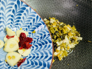 10、酸菜炖粉条,放入蒜片、干辣椒翻炒均匀