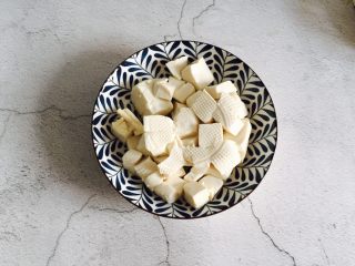 1、洋葱肉末烩豆腐,豆腐清洗一下切块，锅中加入水烧开，加适量盐放入豆腐焯水两分钟，然后捞出沥水装盘备用