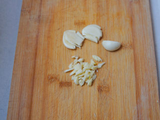 5、水煮千张,大蒜用刀拍碎，再改刀切成细末