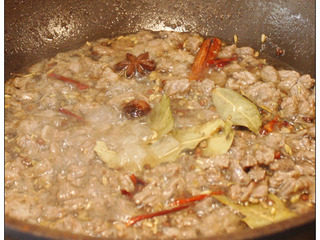 5、牛肉干笋臊子,锅里放油，热后用中火，倒入牛肉粒翻炒，刚开始会有很多泡泡，水份炒干会消失，牛肉要用油多炸一下，期间放入冰糖、花椒、八角、香叶、桂皮、草果和小茴香。