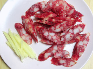 4、蒜苗炒腊肠,腊肠斜刀切成薄片,姜切成姜丝待用。