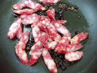 7、蒜苗炒腊肠,放入腊肠翻炒均匀。