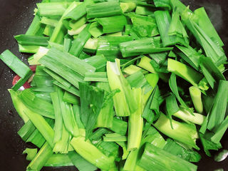 10、蒜苗炒腊肠,放入蒜苗翻炒均匀。