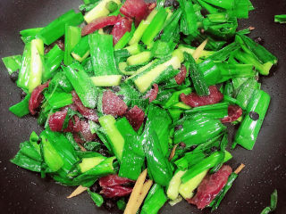 11、蒜苗炒腊肠,放入少量盐,翻炒均匀。