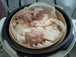 7、麻辣粉蒸排骨,把芋头切片，蒸肉粉拌匀，铺在底部