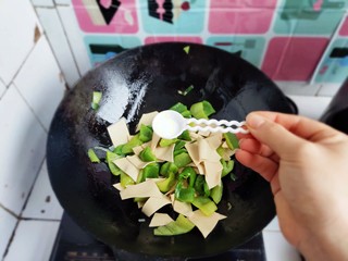 13、家常尖椒炒豆片,加入适量盐。