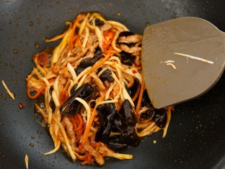 7、鱼香肉丝,锅中烧热,倒入油烧到八成热,放入腌制好的肉丝,炒至变色,加入豆瓣酱,辣椒翻炒