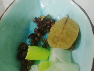 6、鲜香辣牛蛙,倒入葱,香叶,花椒和麻椒。
